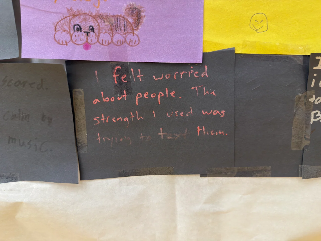 A handwritten note describes worry during a storm beneath a drawing on purple paper.